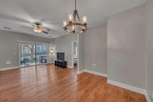 a view of a livingroom with wooden floor and a ceiling fan