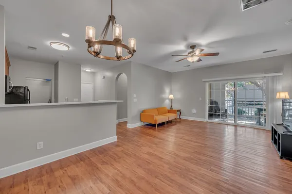 a view of a room with wooden floor and ceiling fan