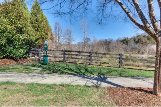a view of a yard with wooden fence
