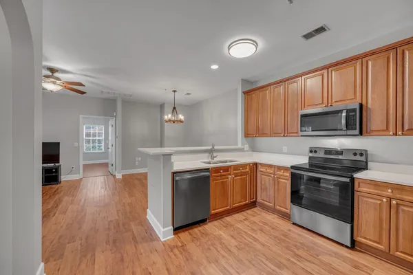 a kitchen with stainless steel appliances granite countertop wooden cabinets a stove top oven a sink and dishwasher