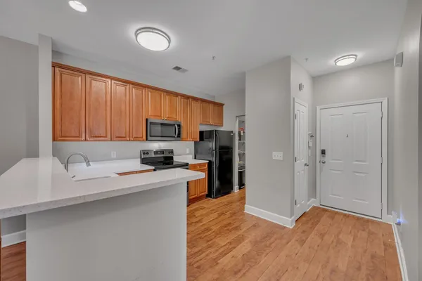 a kitchen with stainless steel appliances granite countertop a sink refrigerator stove microwave and cabinets