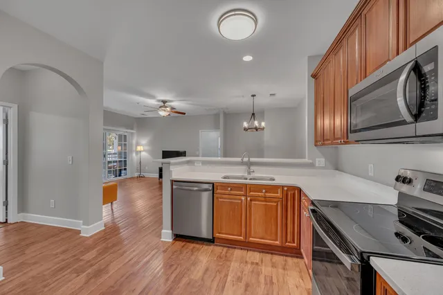 a kitchen with stainless steel appliances granite countertop a sink dishwasher stove and oven with wooden floor