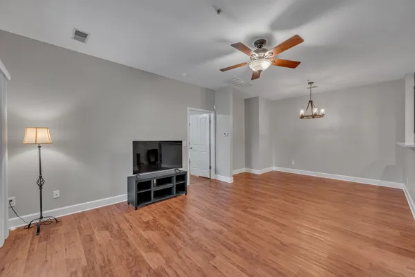 an empty room with fan and windows