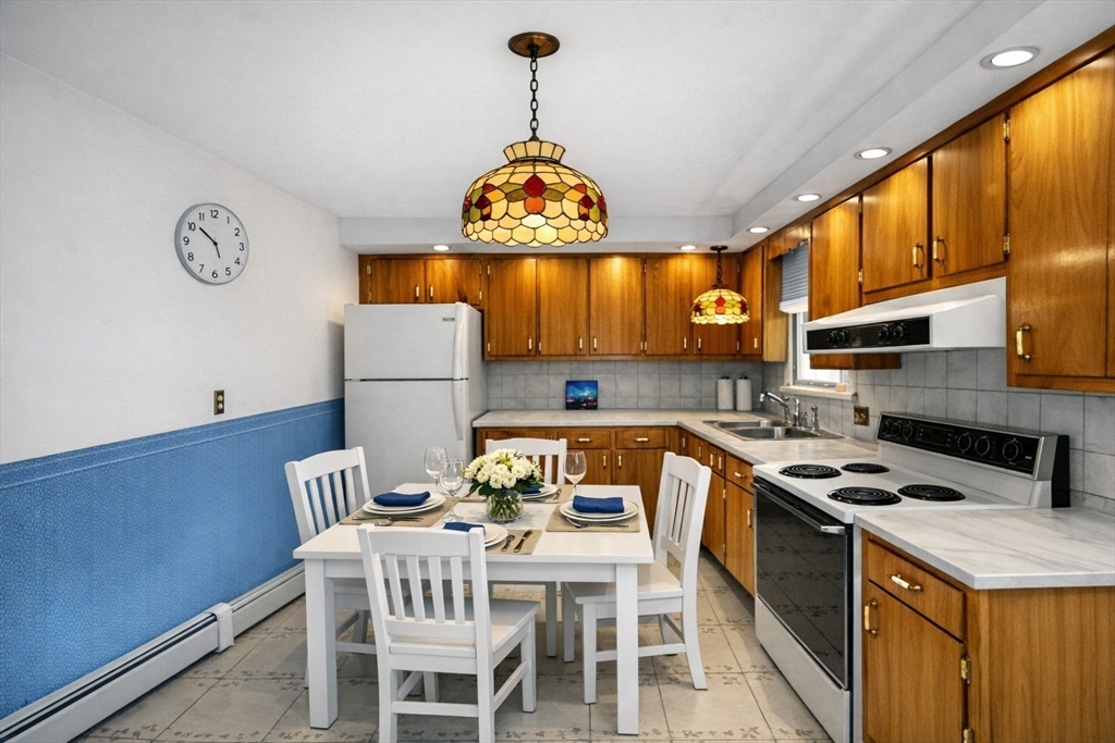 7 Cedarcrest Road Salem, MA 01970 - Photo 8 of 41 a kitchen with stainless steel appliances granite countertop a stove refrigerator a sink dishwasher a dining table and chairs with wooden floor