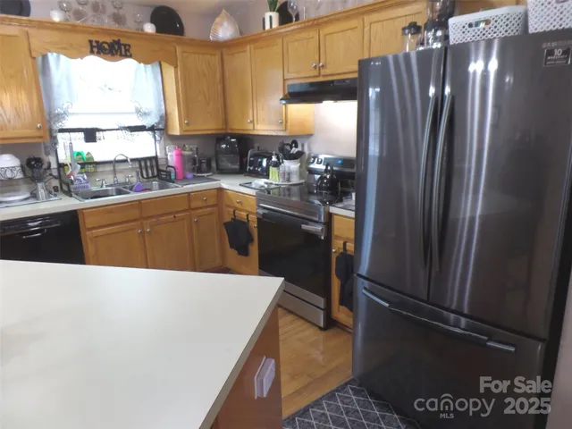 a kitchen with stainless steel appliances a refrigerator sink and cabinets