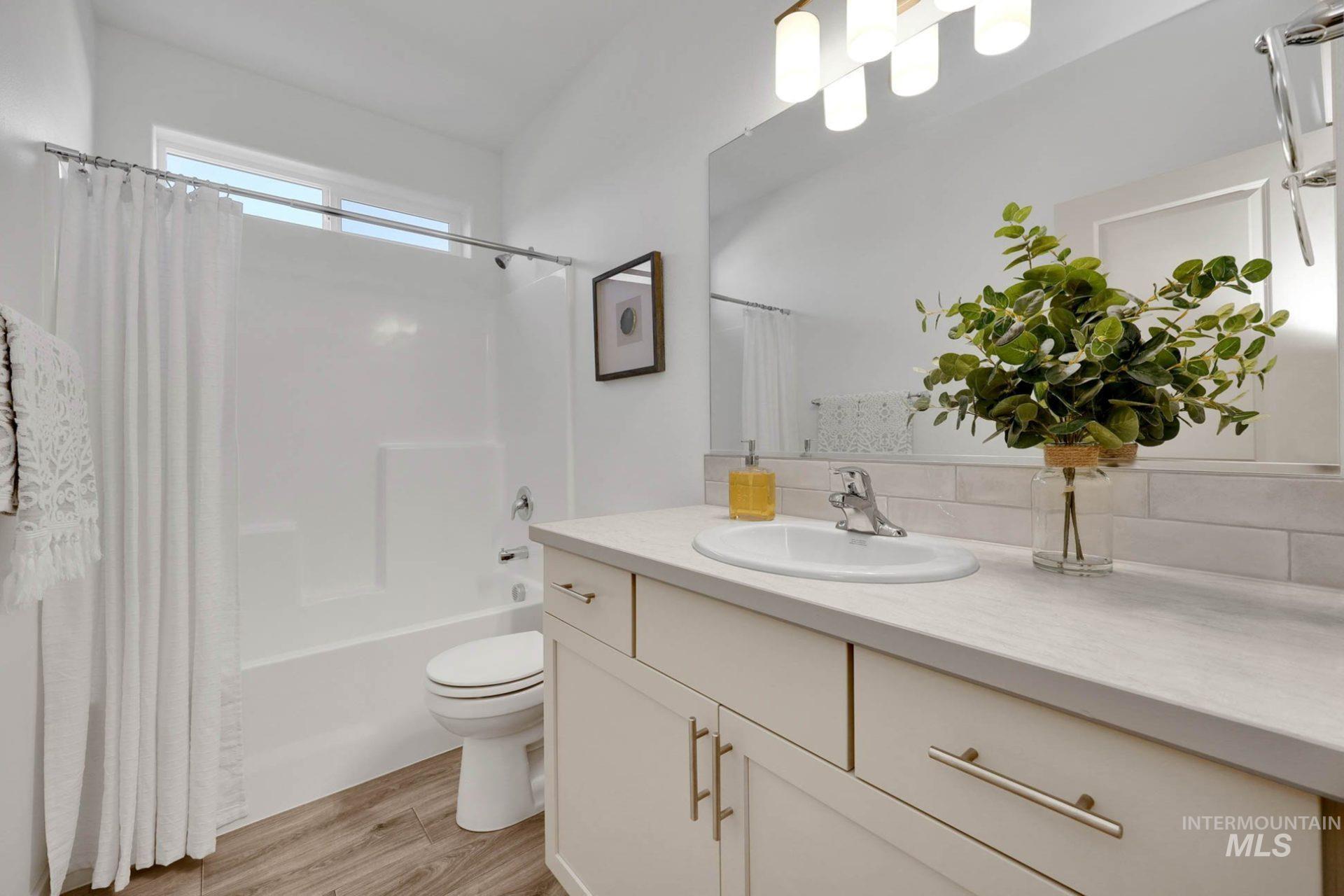 3305 East Fitz Roy Street Kuna, ID 83634 - Photo 16 of 23 Bathroom with shower / bath combo with shower curtain, vanity, and light wood-style flooring