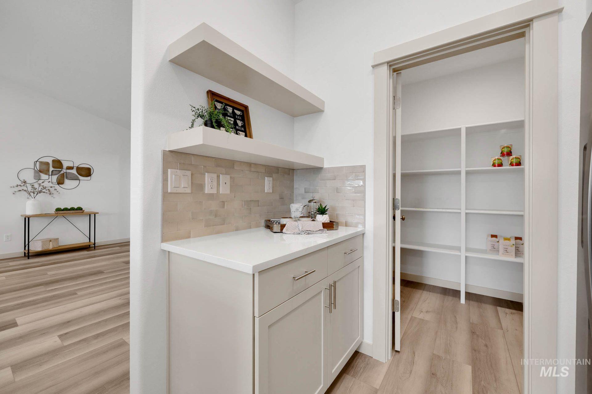3305 East Fitz Roy Street Kuna, ID 83634 - Photo 5 of 23 Bar featuring light wood finished floors, open shelves, backsplash, and white cabinets