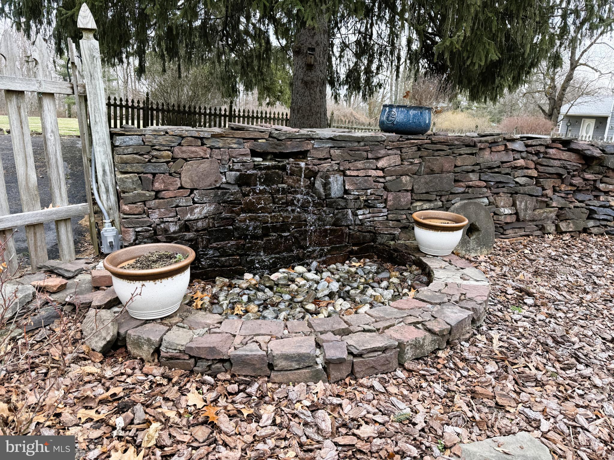 209 Morris Road Lansdale, PA 19446 - Photo 38 of 46 Tranquil stone fountain in a serene garden.