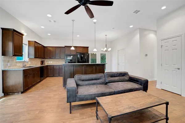 a kitchen with a stove and a wooden floor