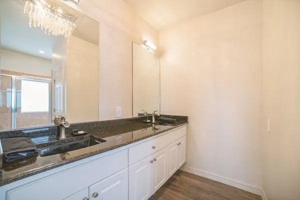 a bathroom with a granite countertop sink a toilet a mirror and shower