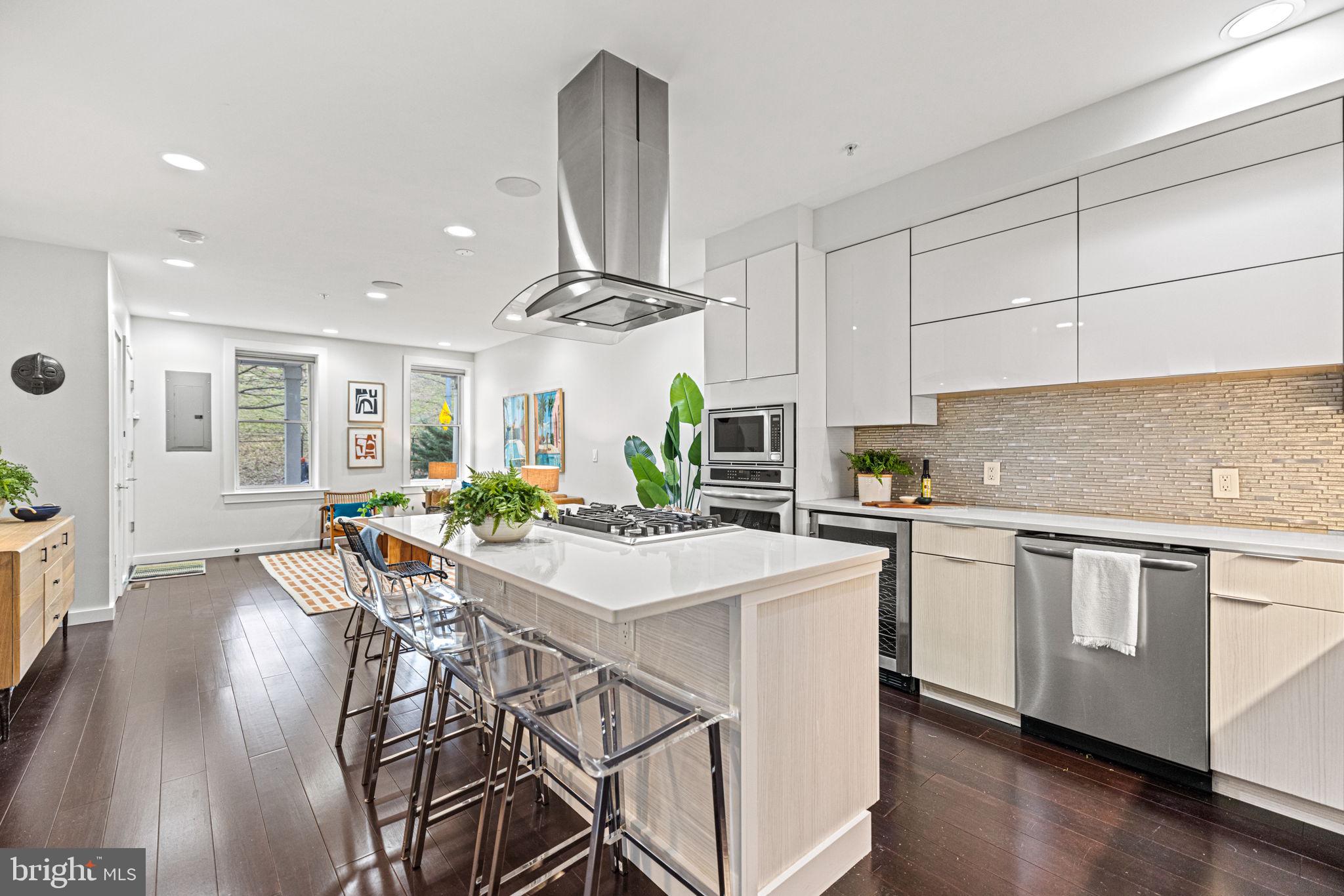 a kitchen with stainless steel appliances a dining table chairs stove and cabinets
