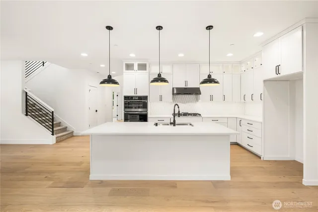 an empty room with windows and fireplace