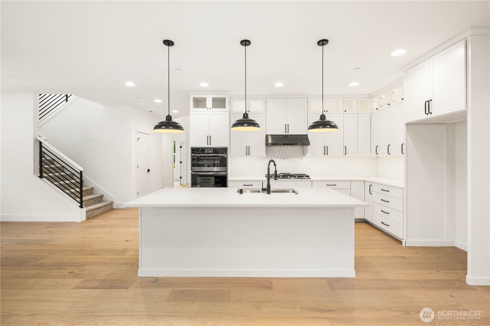 722 211th Place Southeast Bothell, WA 98021 - Photo 7 of 27 a large kitchen with kitchen island a stove a sink a center island a refrigerator and a wooden floor