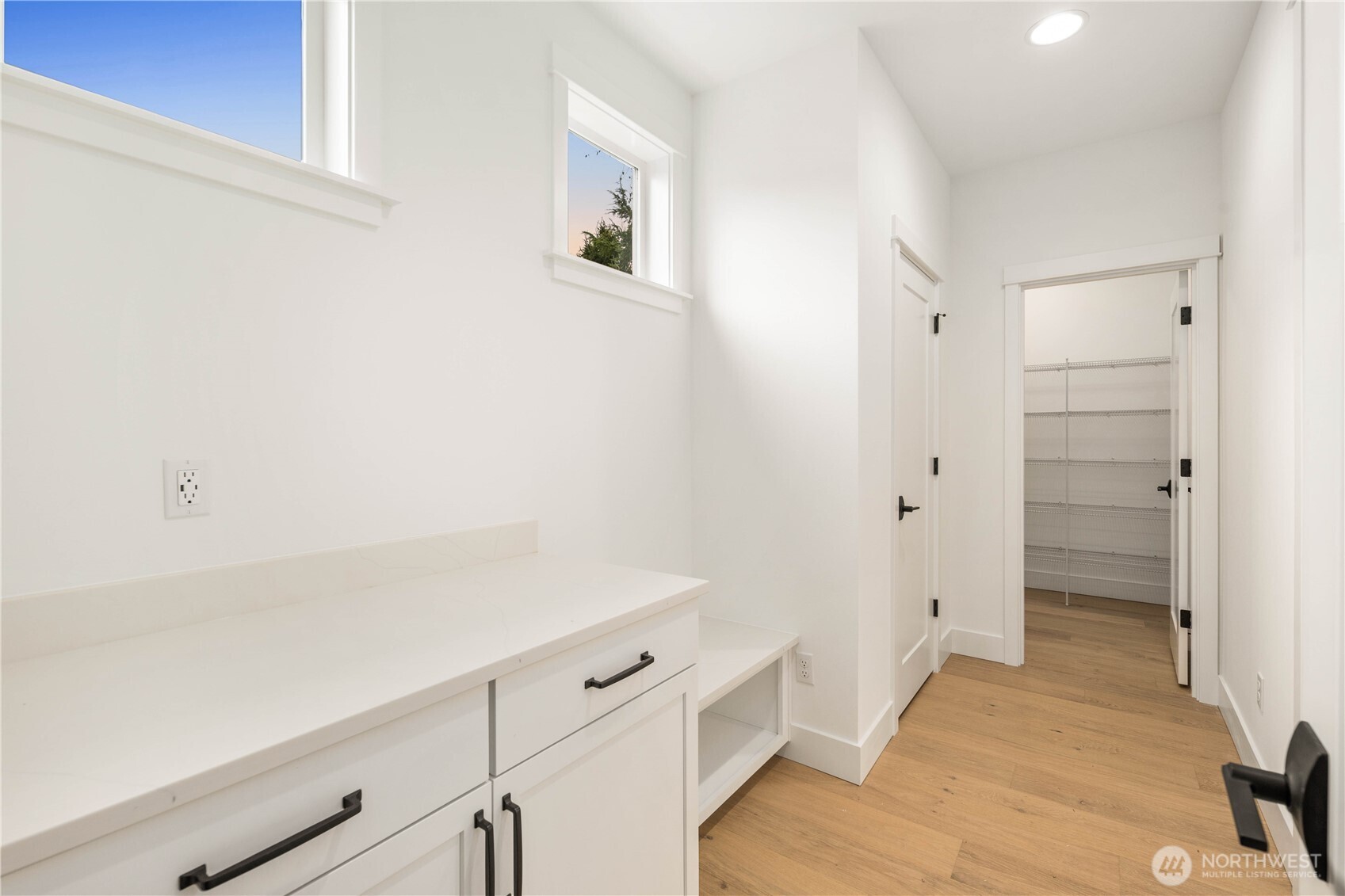 722 211th Place Southeast Bothell, WA 98021 - Photo 8 of 27 a hallway with white cabinets and wooden floor