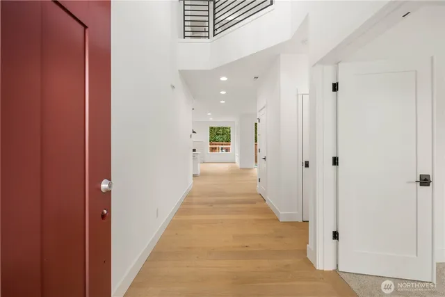a large white kitchen with kitchen island a sink wooden floor and a large window