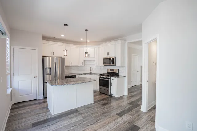 a kitchen with stainless steel appliances a refrigerator and a stove top oven