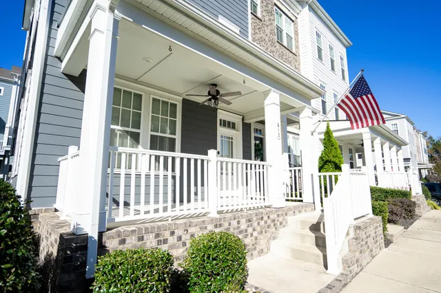 a view of a house with a small yard and wooden fence