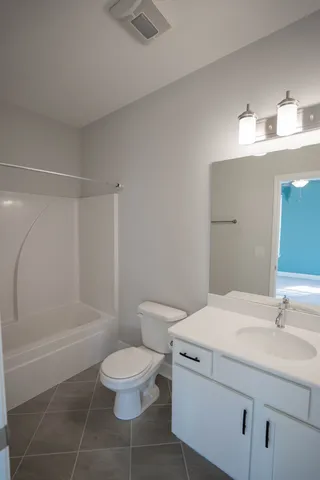 a bathroom with a granite countertop sink toilet a mirror and shower