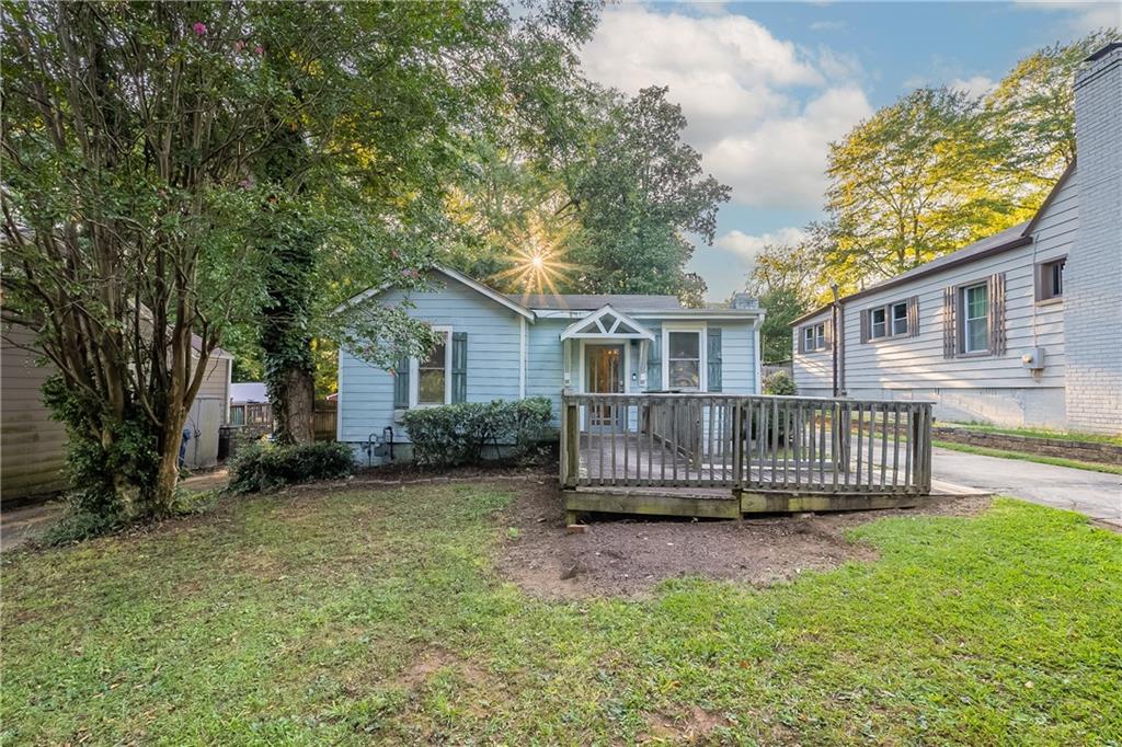 a view of a house with a yard and deck