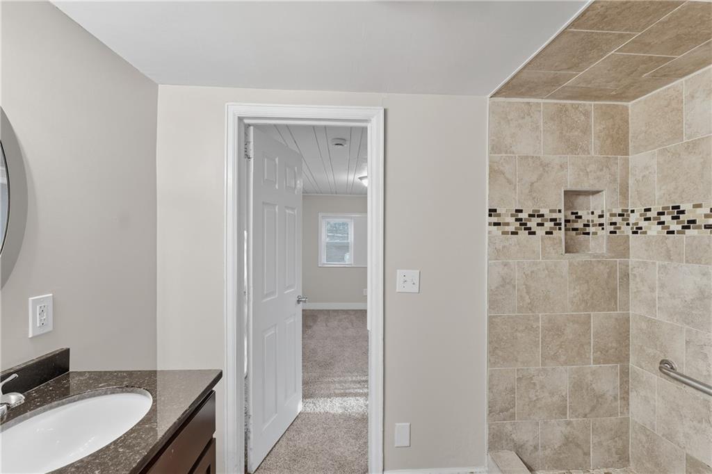 55 Wyman Street Southeast Atlanta, GA 30317 - Photo 20 of 25 a bathroom with a granite countertop sink a toilet and shower