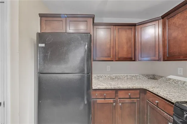 a kitchen with granite countertop cabinets and refrigerator