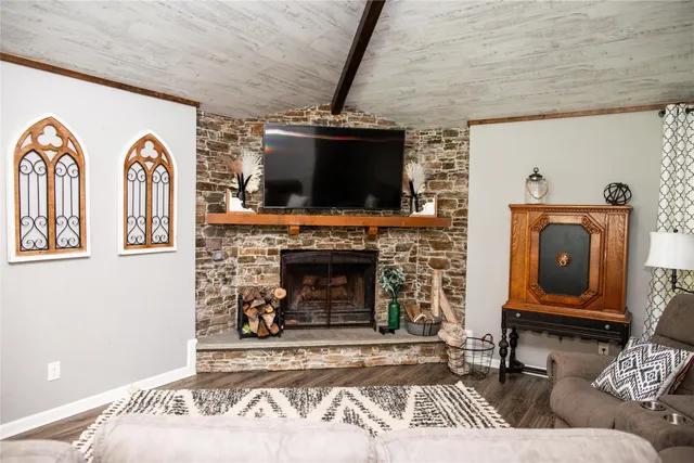 a living room with furniture a flat screen tv and a fireplace