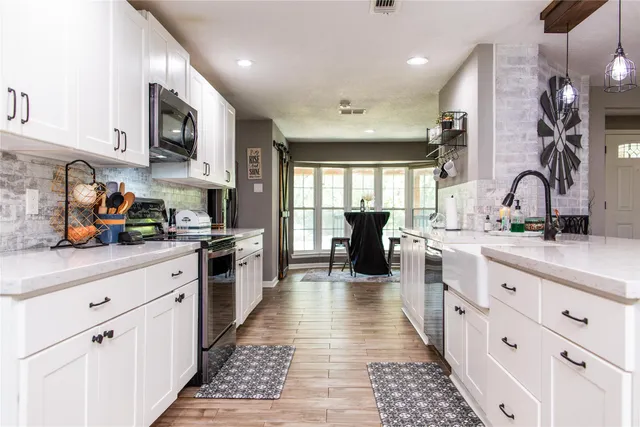 a large kitchen with stainless steel appliances lots of counter space and a sink