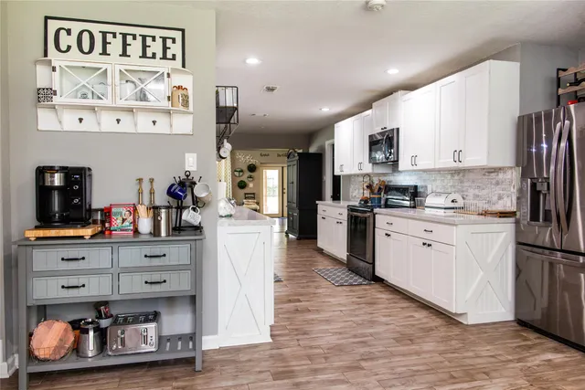 a kitchen with stainless steel appliances granite countertop a refrigerator and a stove top oven