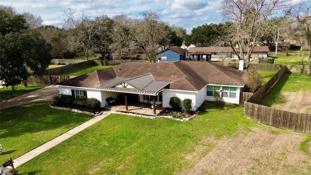 an aerial view of a house with swimming pool garden and patio