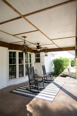 a view of a patio with table and chairs with wooden floor and fence