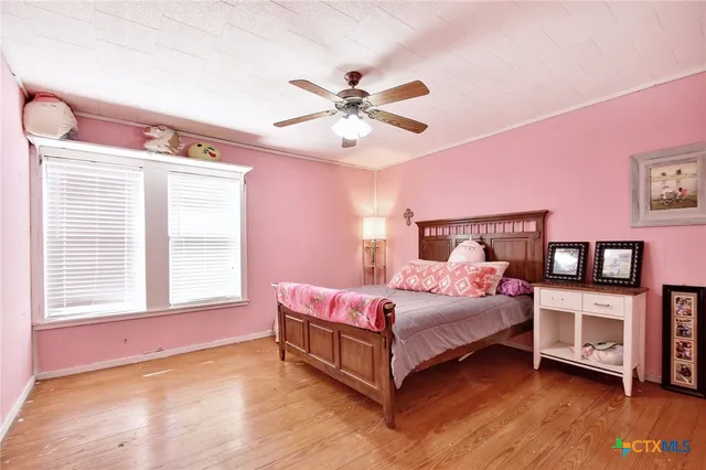 a bedroom with a bed chandelier and a window