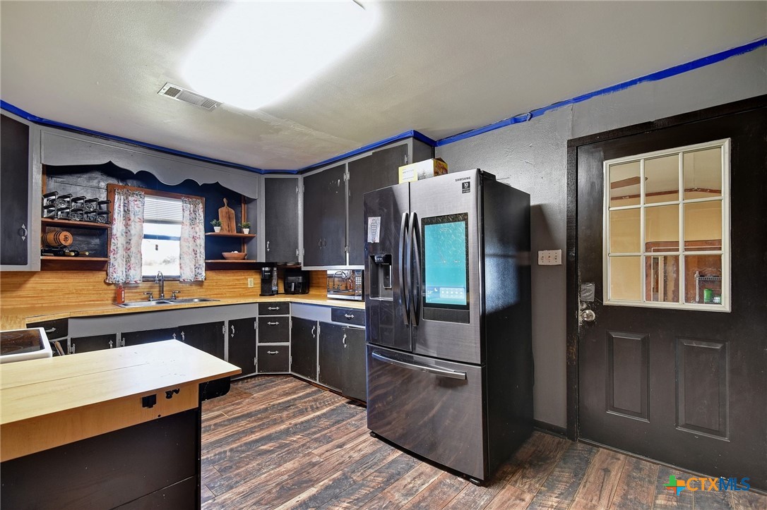 1017 Highway 87 Smiley, TX 78159 - Photo 10 of 30 a kitchen with stainless steel appliances kitchen island granite countertop a refrigerator stove and sink