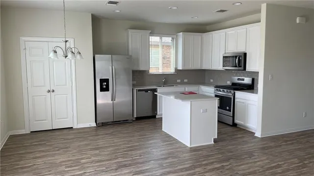 a kitchen with stainless steel appliances granite countertop a refrigerator stove and sink