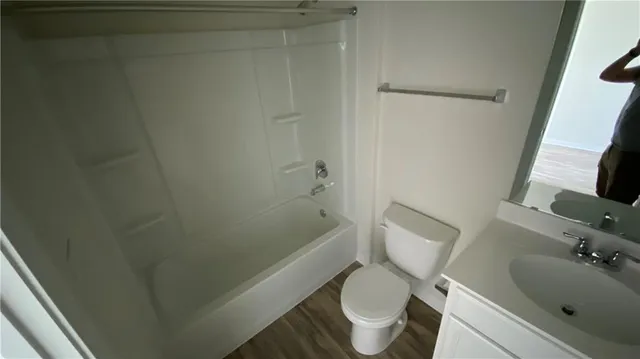 a white toilet sitting next to a bath tub