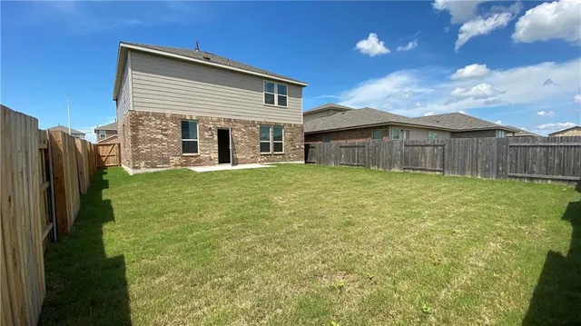 a view of a house with a yard and a large tree
