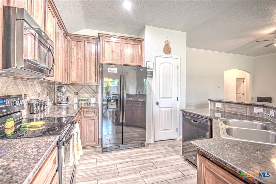 2520 Nolan Creek Street Temple, TX 76504 - Photo 13 of 32 a kitchen with a refrigerator a sink and wooden cabinets