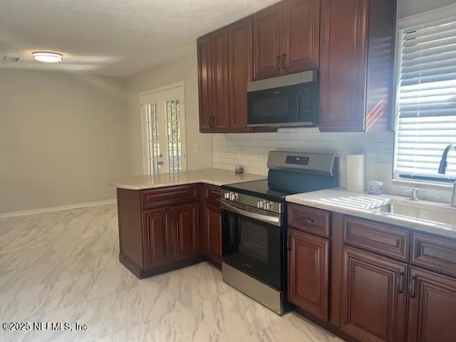 a kitchen with stainless steel appliances granite countertop a sink stove and microwave