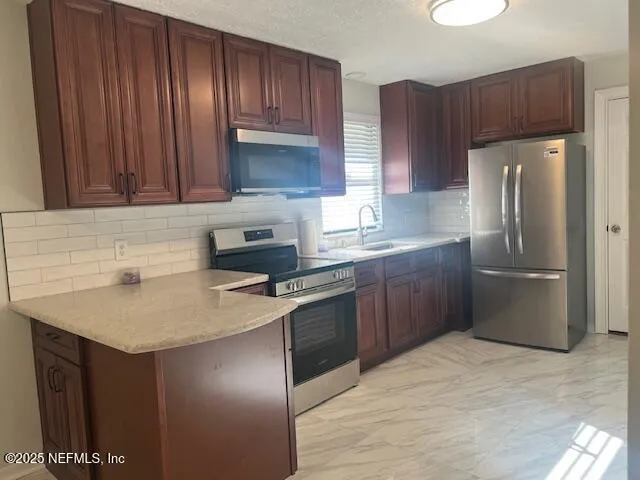 a kitchen with a sink refrigerator and cabinets