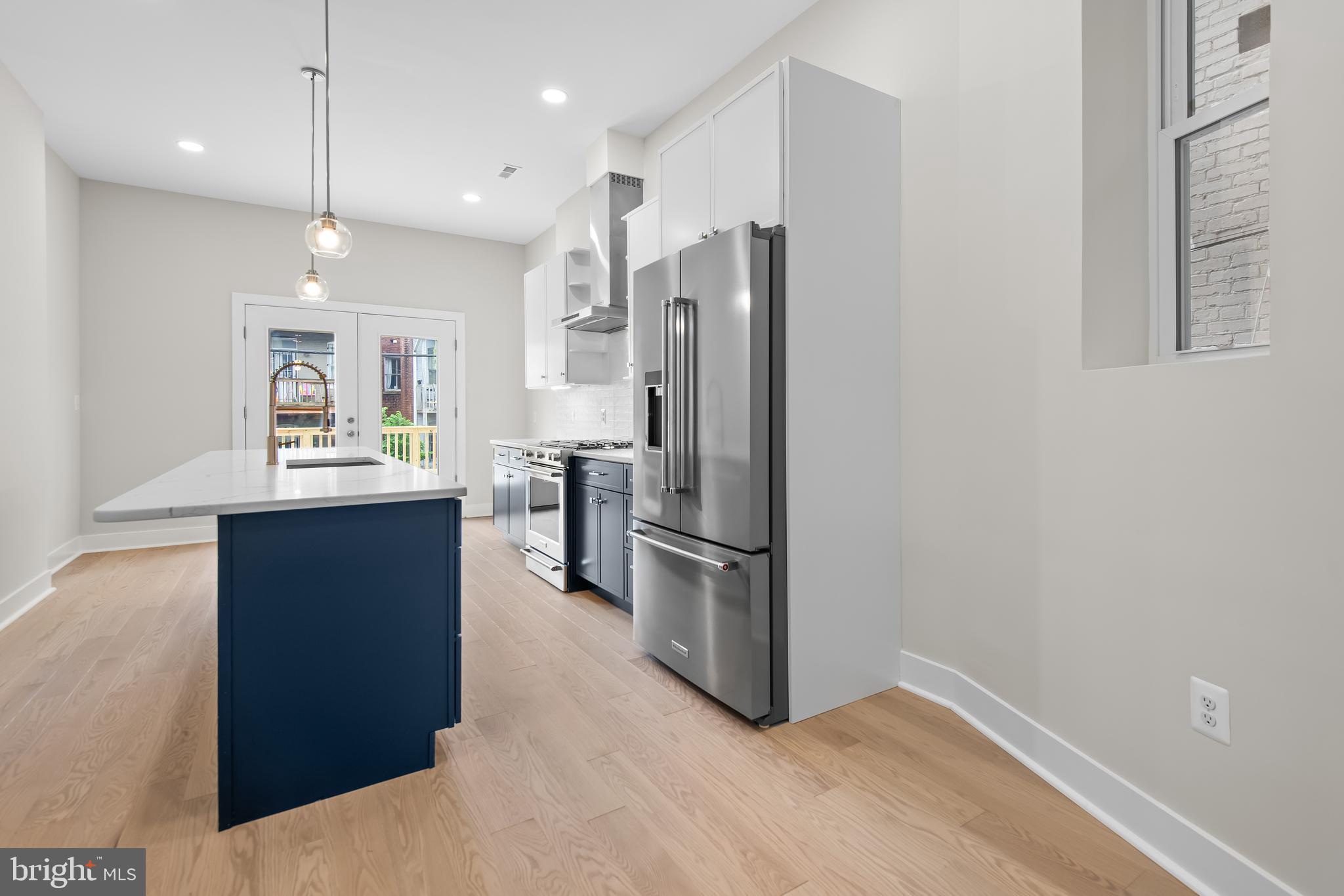 20 T Street Northwest, Unit 2 Washington, DC 20001 - Photo 10 of 31 a kitchen with kitchen island a counter top space a sink stainless steel appliances and cabinets
