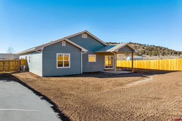 a view of a house with a yard and potted plants