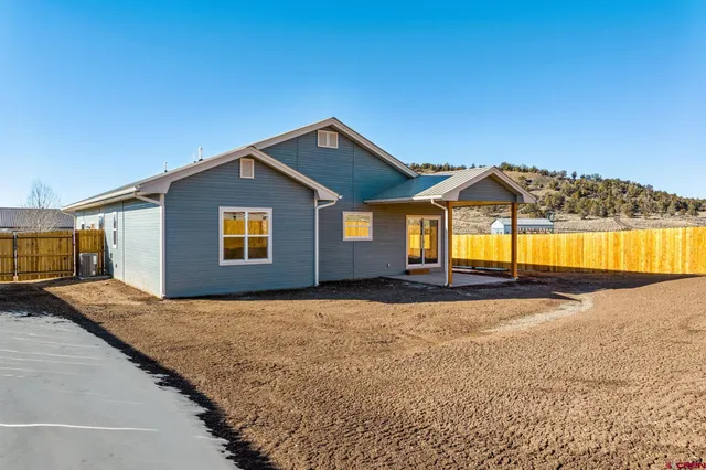 a view of a house with a yard and potted plants