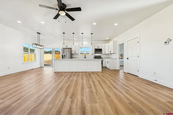 a view of a kitchen with wooden floor and electronic appliances