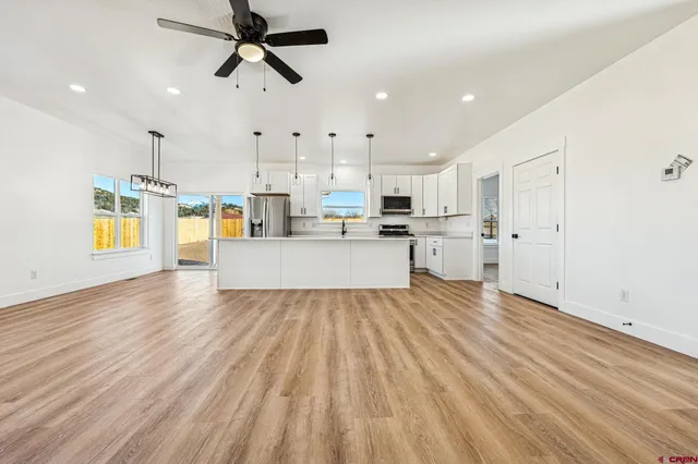 a view of a kitchen with wooden floor and electronic appliances