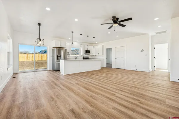 a view of a kitchen with wooden floor and a ceiling fan