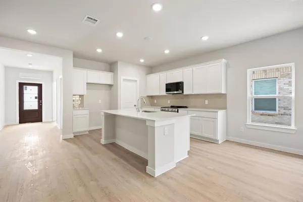a open kitchen with white cabinets and white appliances
