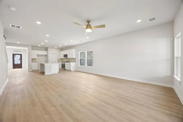 a view of kitchen with kitchen island wooden floor center island and stainless steel appliances