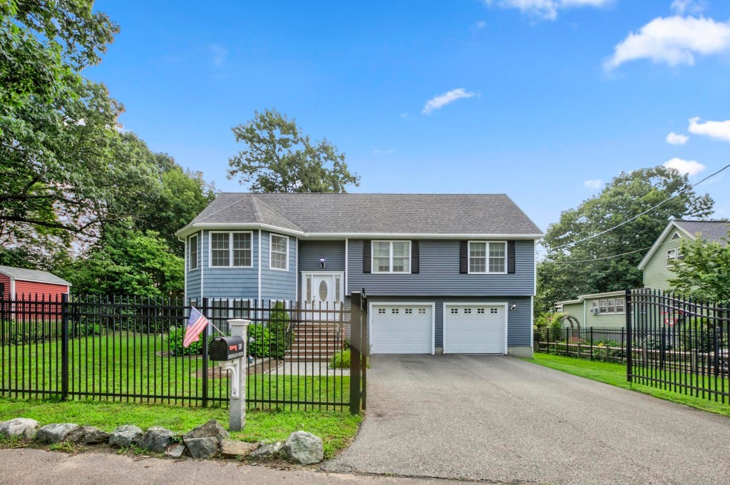10 Emerald Court Stoneham, MA 02180 - Photo 1 of 42 a front view of a house with a garden and plants