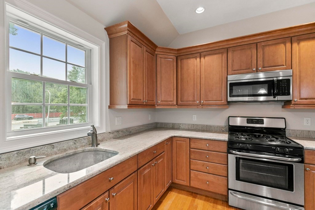 10 Emerald Court Stoneham, MA 02180 - Photo 15 of 42 a kitchen with granite countertop a sink stainless steel appliances and cabinets
