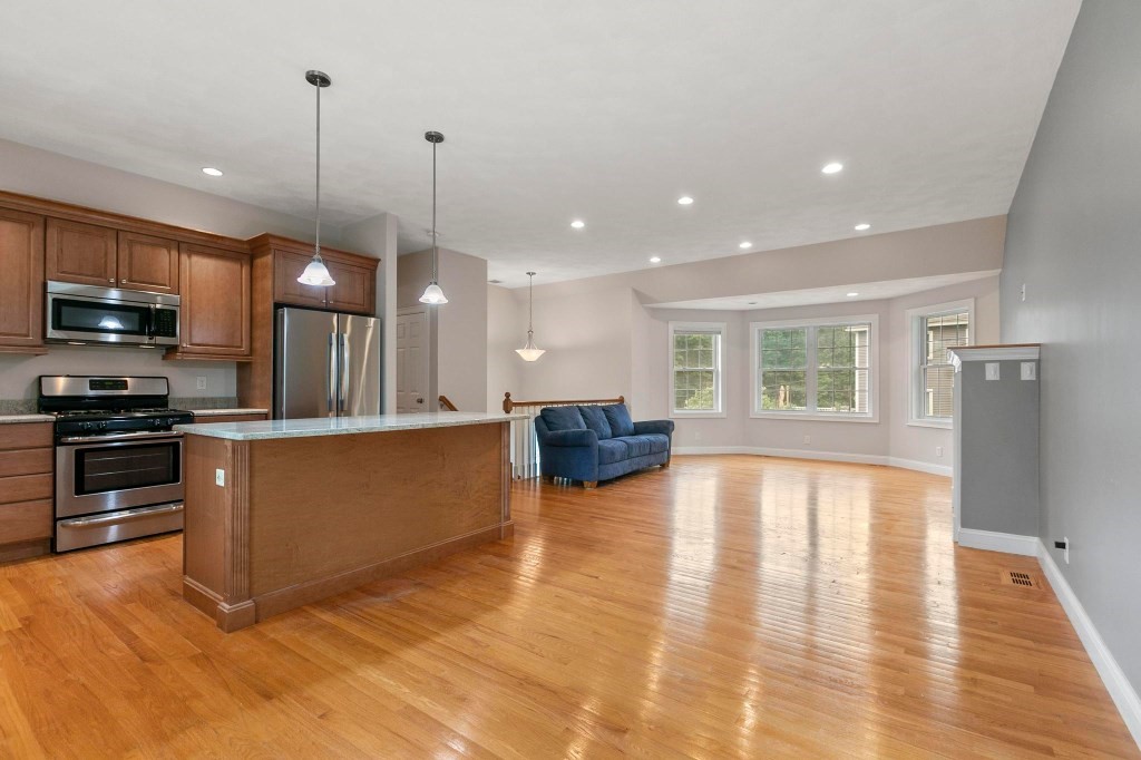 10 Emerald Court Stoneham, MA 02180 - Photo 18 of 42 a open kitchen with stainless steel appliances granite countertop a stove a sink a refrigerator and a wooden cabinets