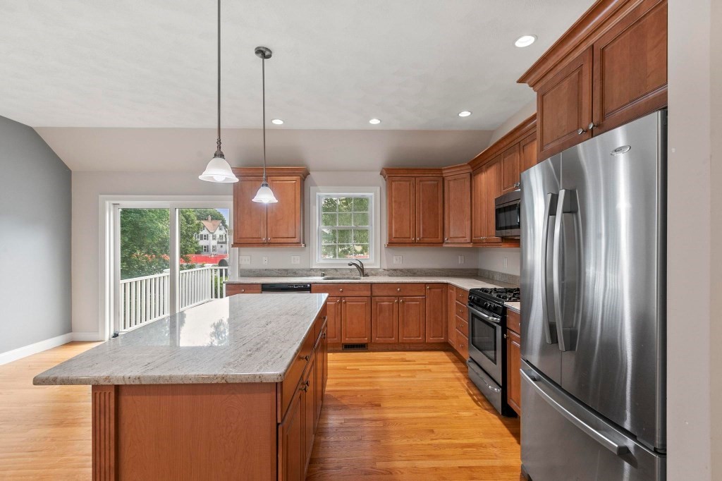 10 Emerald Court Stoneham, MA 02180 - Photo 19 of 42 a kitchen with granite countertop a refrigerator a sink dishwasher a stove and white cabinets with wooden floor